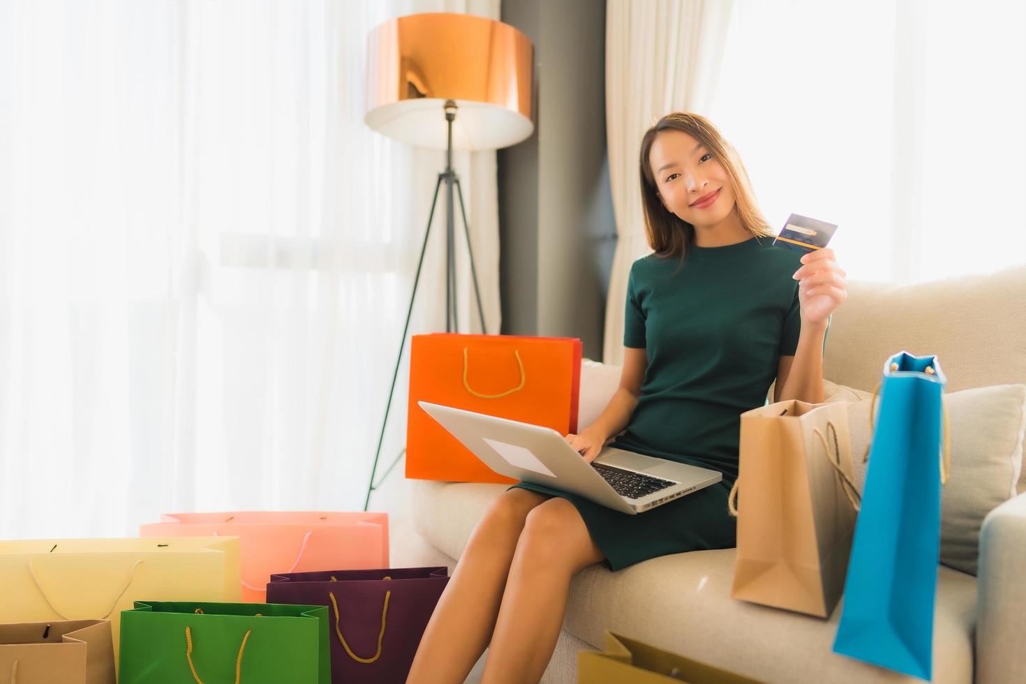 retrato de belas jovens mulheres asiáticas usando computador, laptop ou smartphone e celular com cartão de crédito para fazer compras online foto