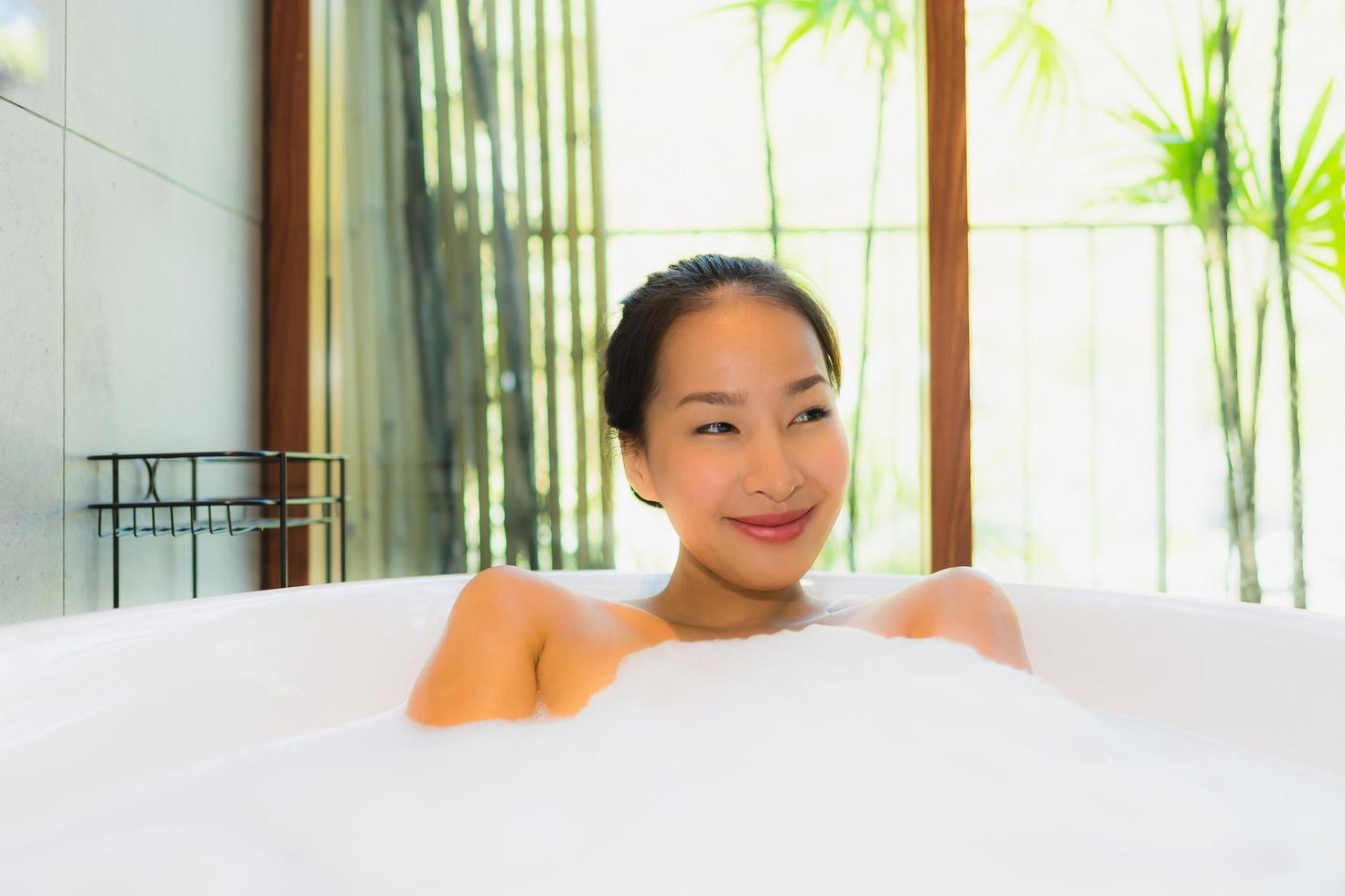 retrato jovem linda mulher asiática tomando banho na banheira foto