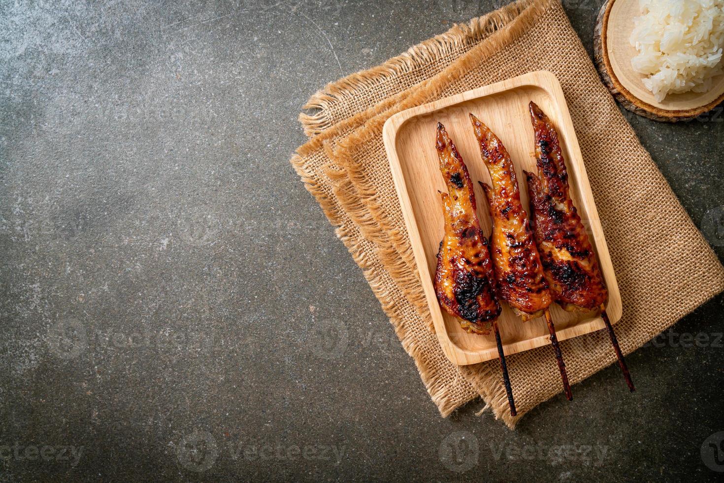 espeto de asas de frango grelhado ou churrasco com arroz pegajoso foto