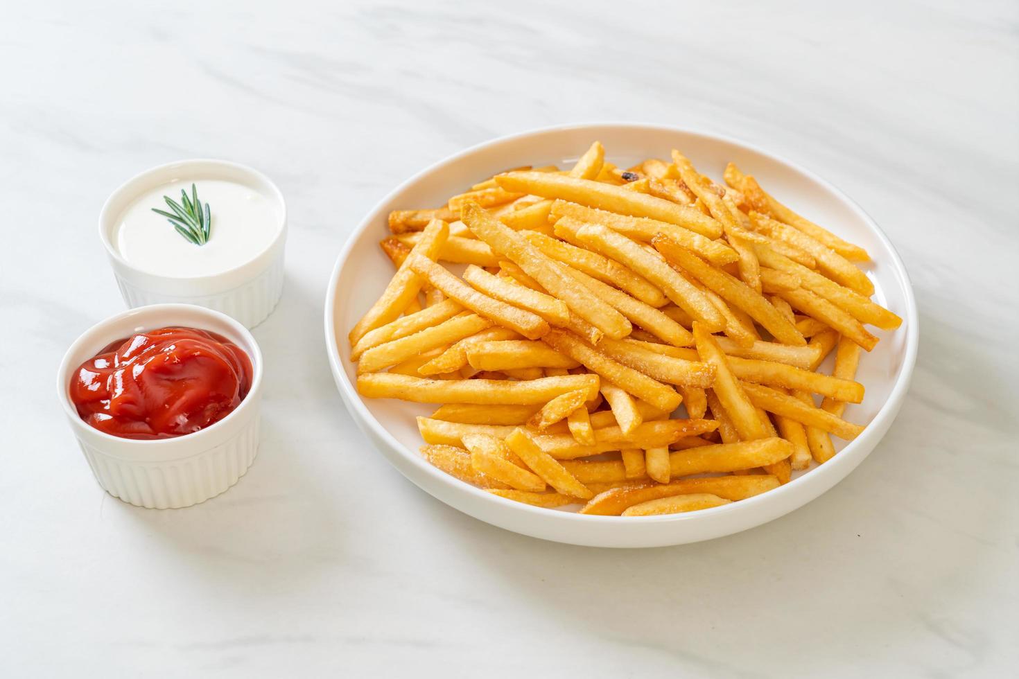 batatas fritas com creme de leite e ketchup foto