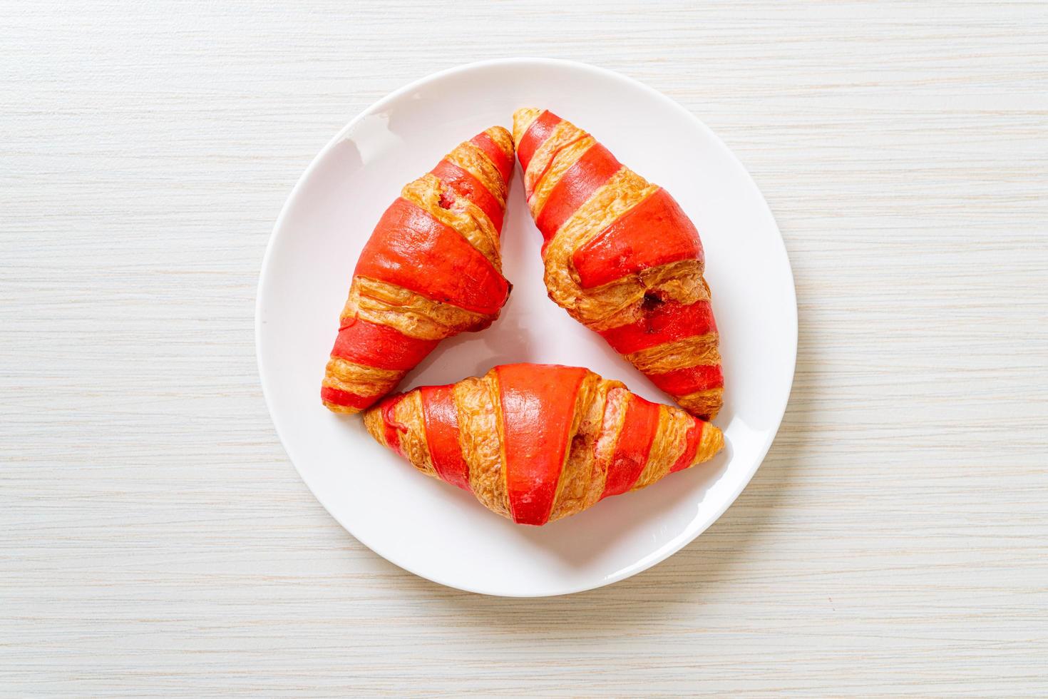 croissant fresco com molho de geleia de morango no prato foto