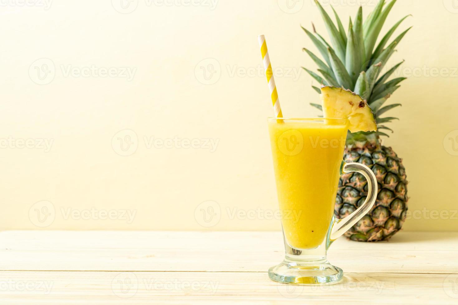 copo de suco de abacaxi fresco na mesa de madeira - bebida saudável foto