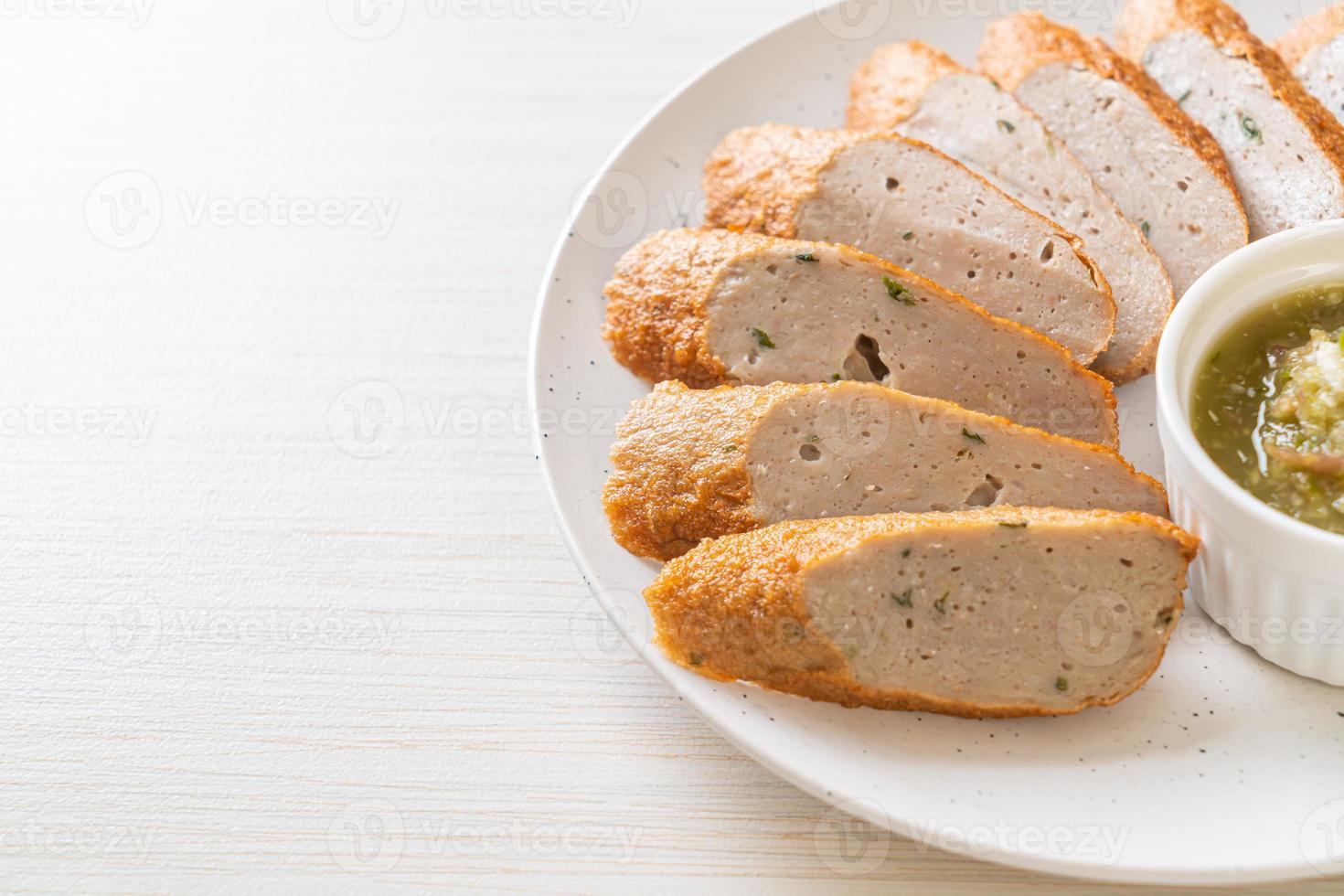 Bolo de peixe chinês frito ou linha de bolinho de peixe fatiado com molho picante de frutos do mar foto