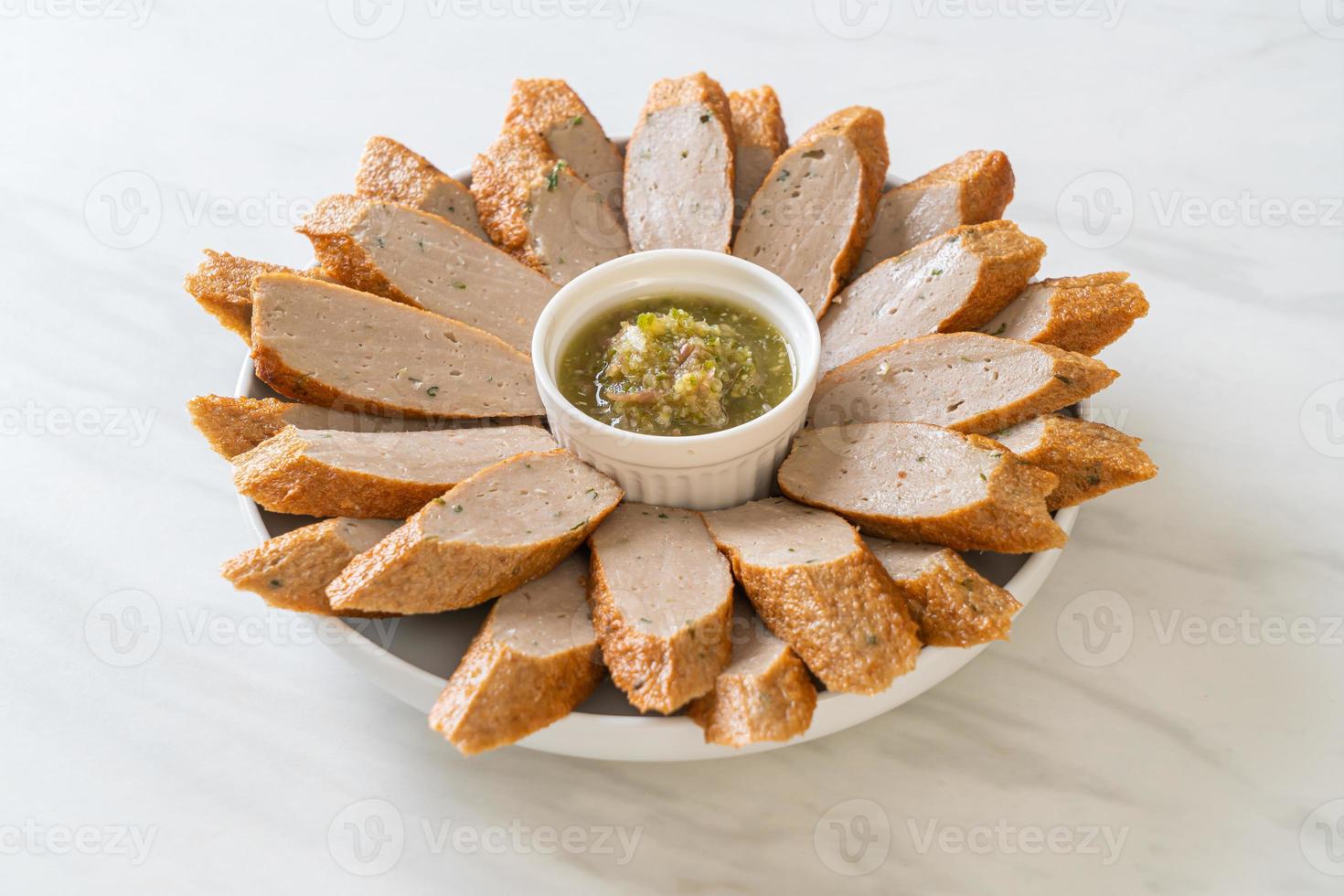 Bolo de peixe chinês frito ou linha de bolinho de peixe fatiado com molho picante de frutos do mar foto