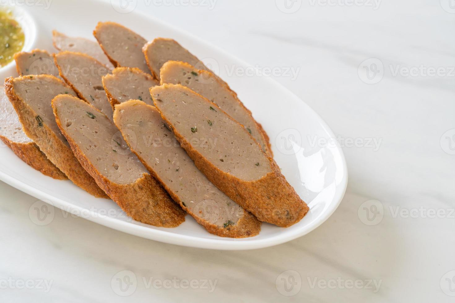 Bolo de peixe chinês frito ou linha de bolinho de peixe fatiado com molho picante de frutos do mar foto