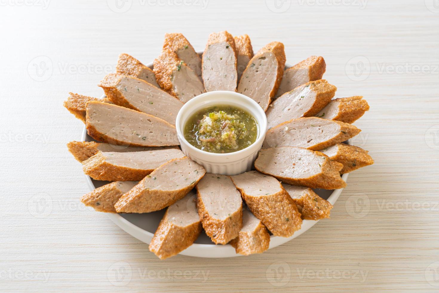 Bolo de peixe chinês frito ou linha de bolinho de peixe fatiado com molho picante de frutos do mar foto