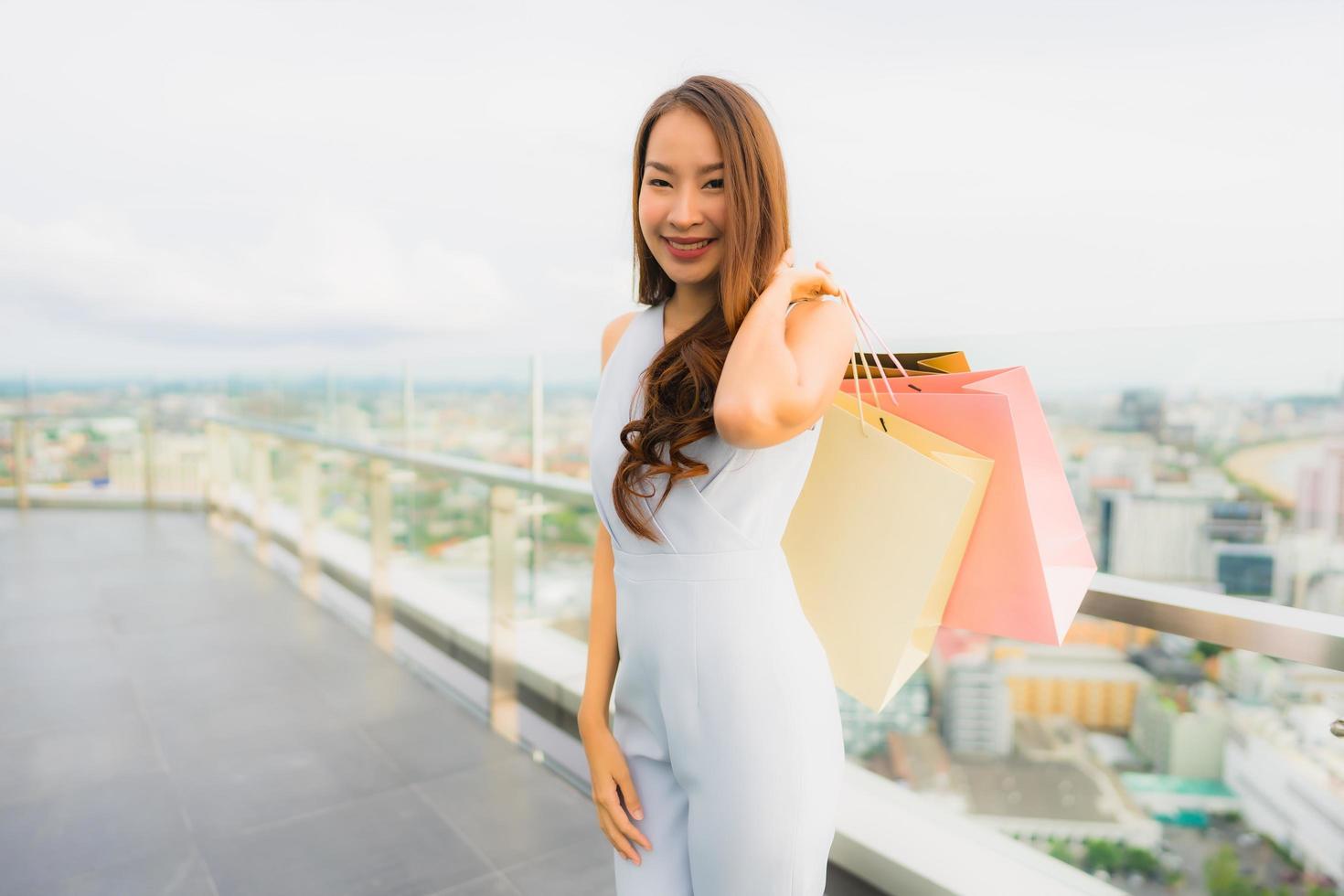 retrato linda jovem asiática feliz e sorrindo com a sacola de compras da loja de departamentos foto