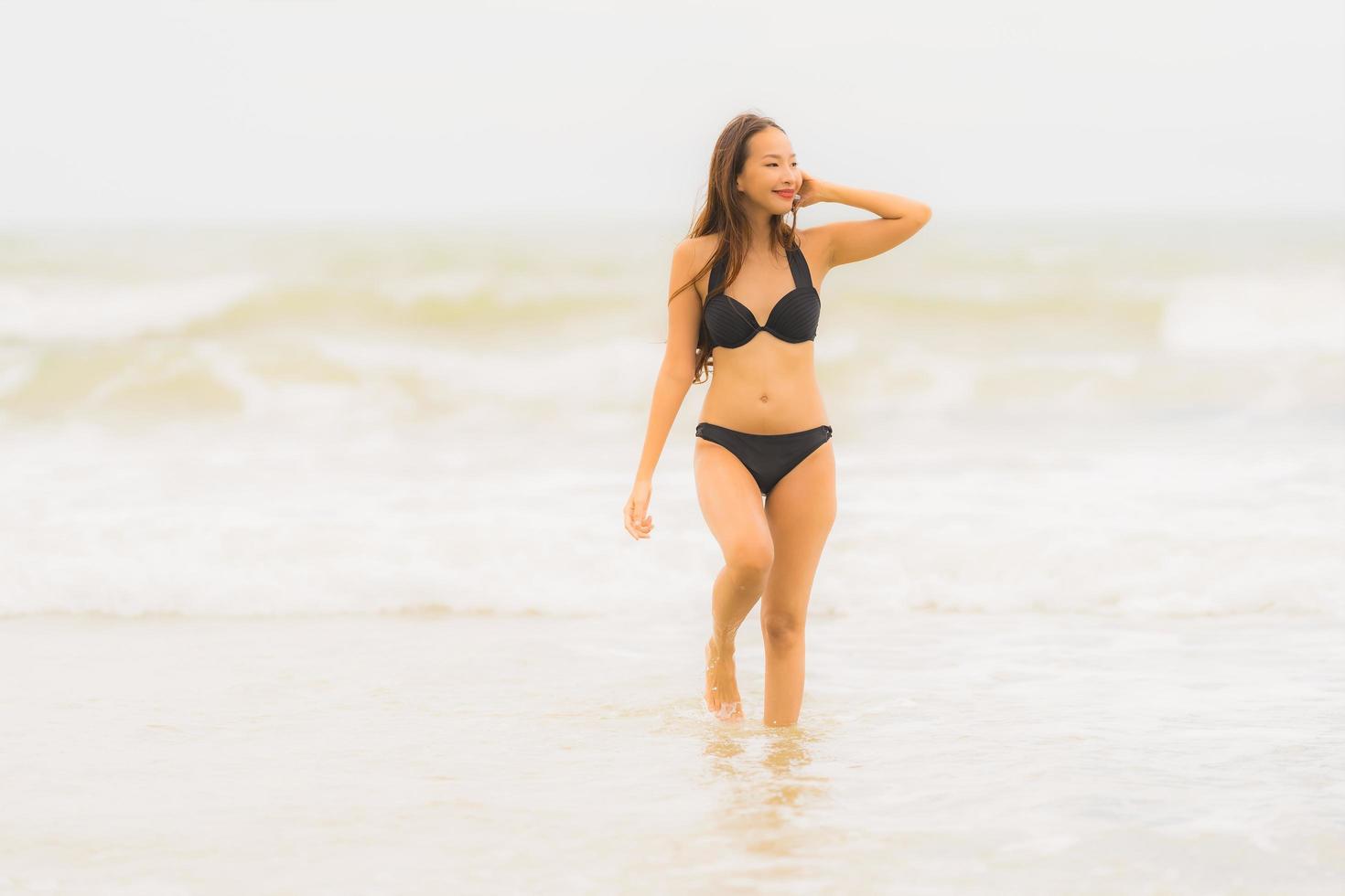 retrato linda jovem asiática usar biquíni na praia, mar, oceano foto