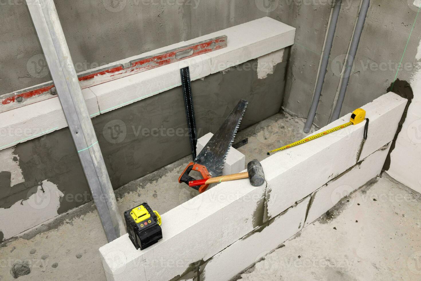 interior do uma Novo banheiro com a concreto blocos e construção ferramentas. foto