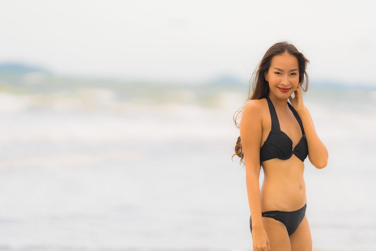 retrato linda jovem asiática usar biquíni na praia, mar, oceano foto
