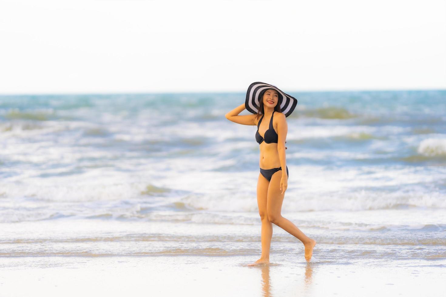 retrato linda jovem asiática usar biquíni na praia, mar, oceano foto