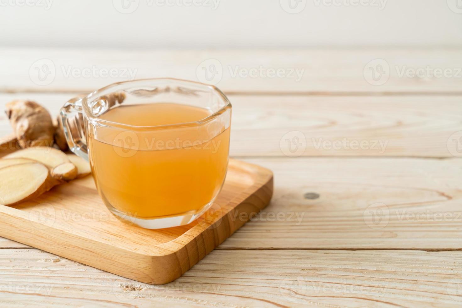 copo de suco de gengibre fresco e quente com raízes de gengibre - estilo de bebida saudável foto