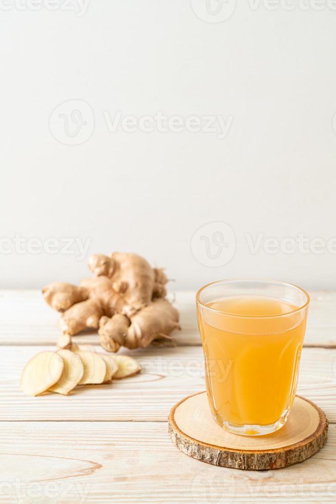 copo de suco de gengibre fresco e quente com raízes de gengibre - estilo de bebida saudável foto