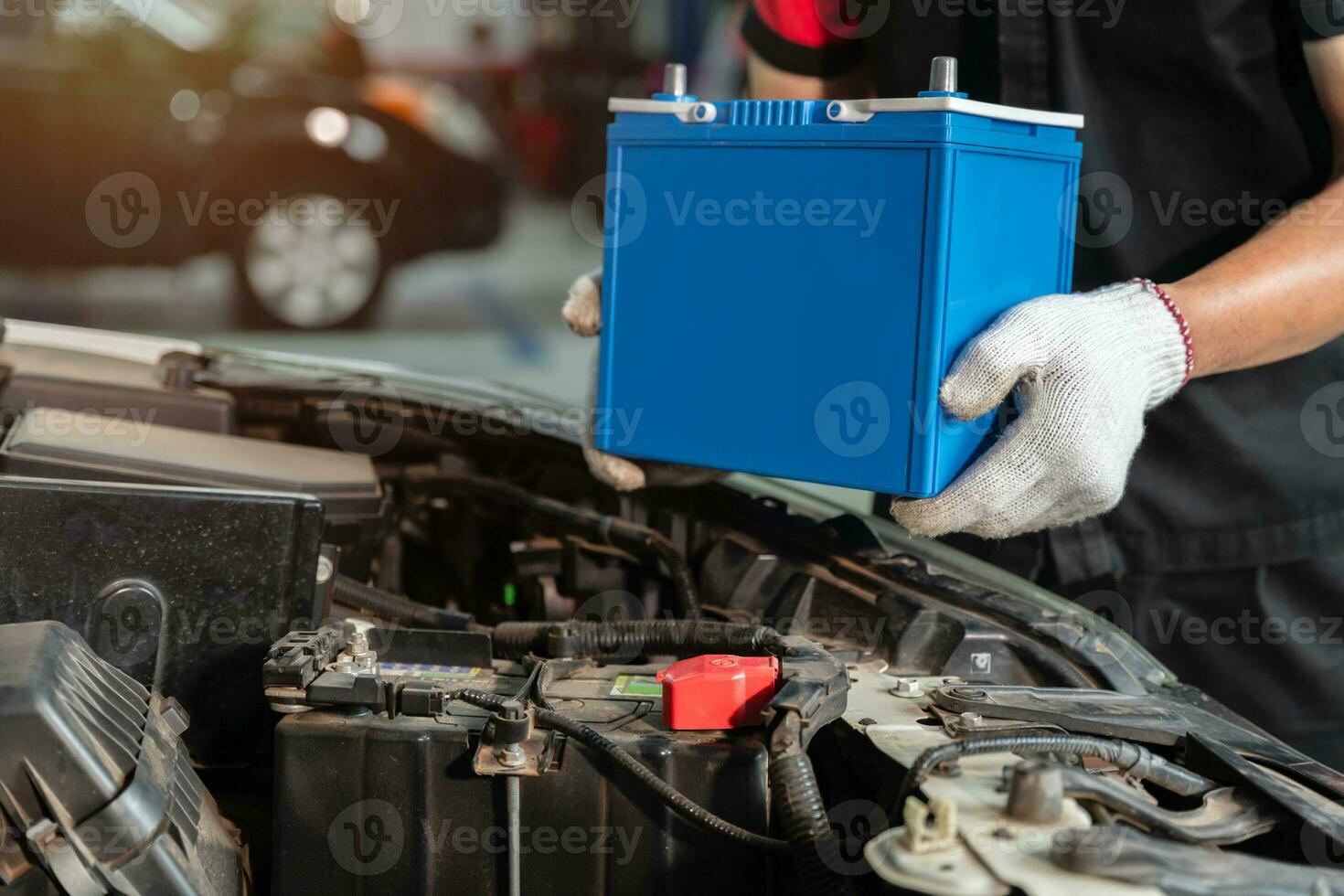 fechar acima mão do masculino mecânico mudando carro bateria às carro serviço Centro, conceito carro manutenção foto