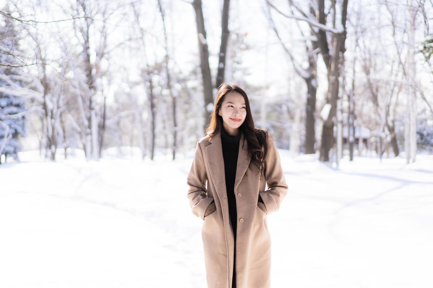 retrato jovem linda mulher asiática sorrir feliz viajar e desfrutar com neve inverno temporada foto