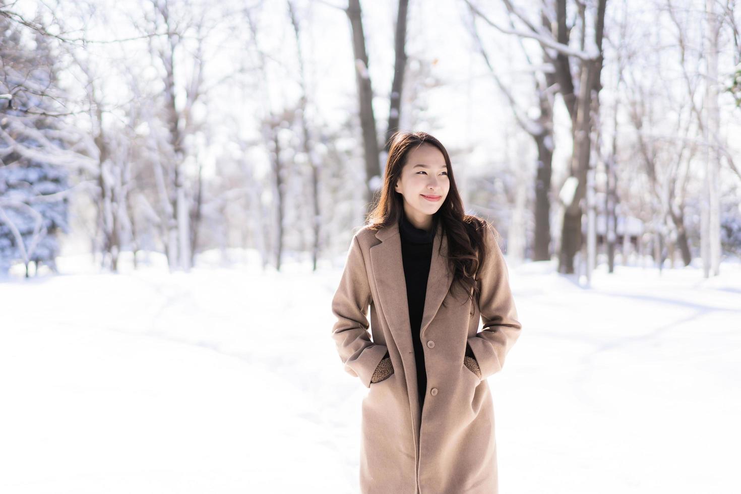 retrato jovem linda mulher asiática sorrir feliz viajar e desfrutar com neve inverno temporada foto