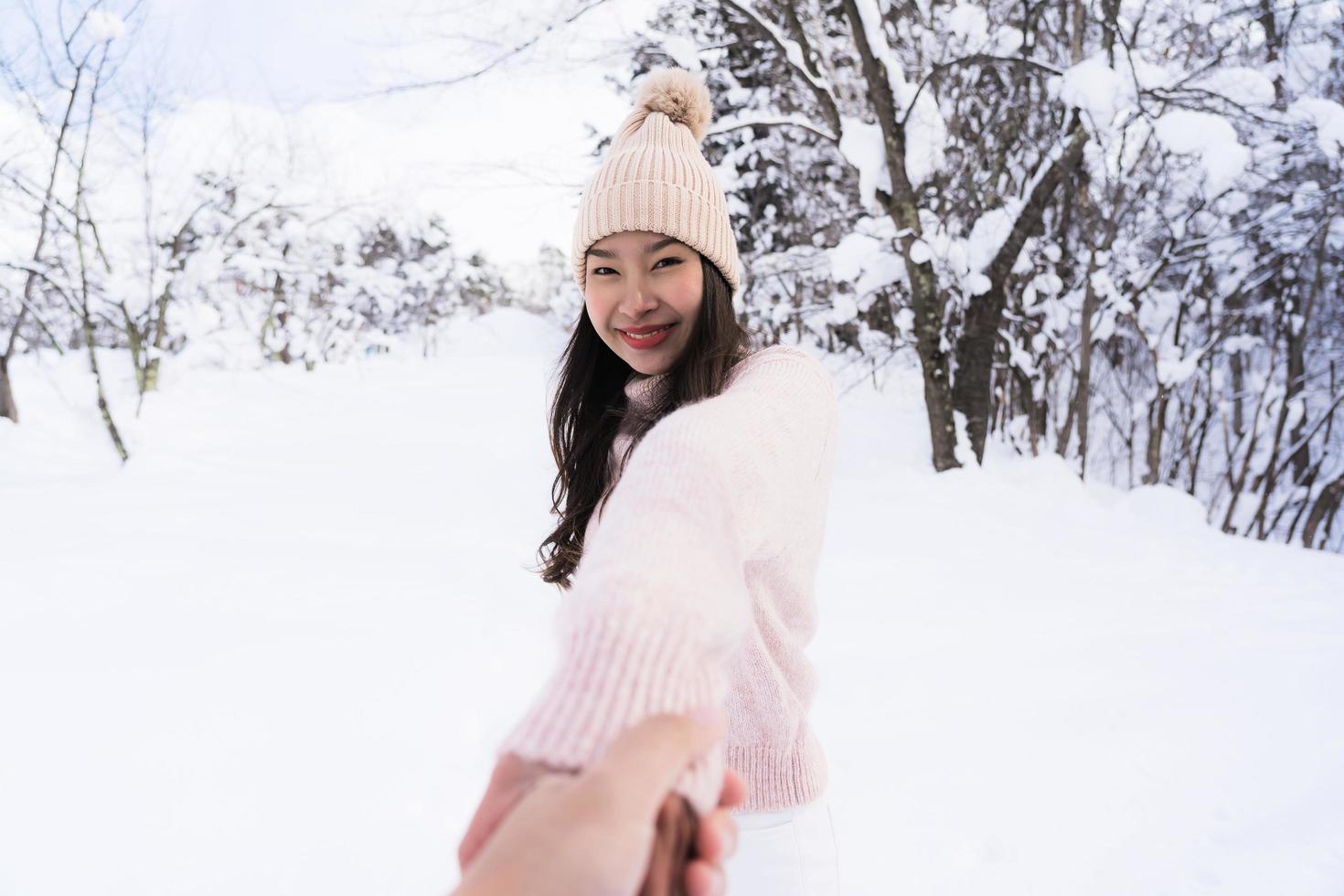 retrato jovem linda mulher asiática sorrir feliz viajar e desfrutar com neve inverno temporada foto