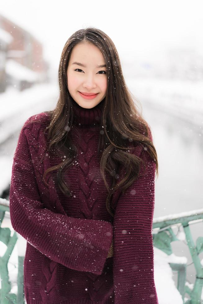 bela jovem asiática sorrindo e feliz com a viagem de viagem no canal otaru hokkaido no japão foto