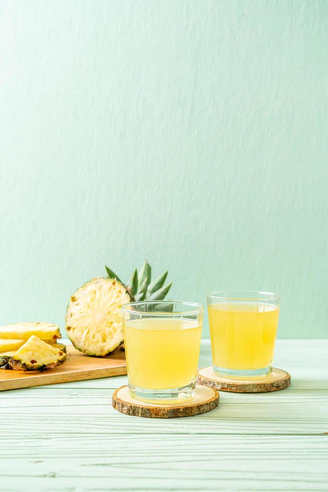 suco de abacaxi fresco em fundo de madeira foto