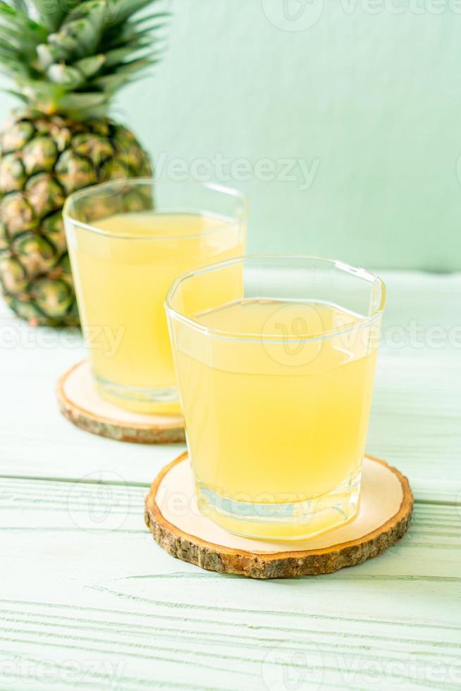 suco de abacaxi fresco em fundo de madeira foto