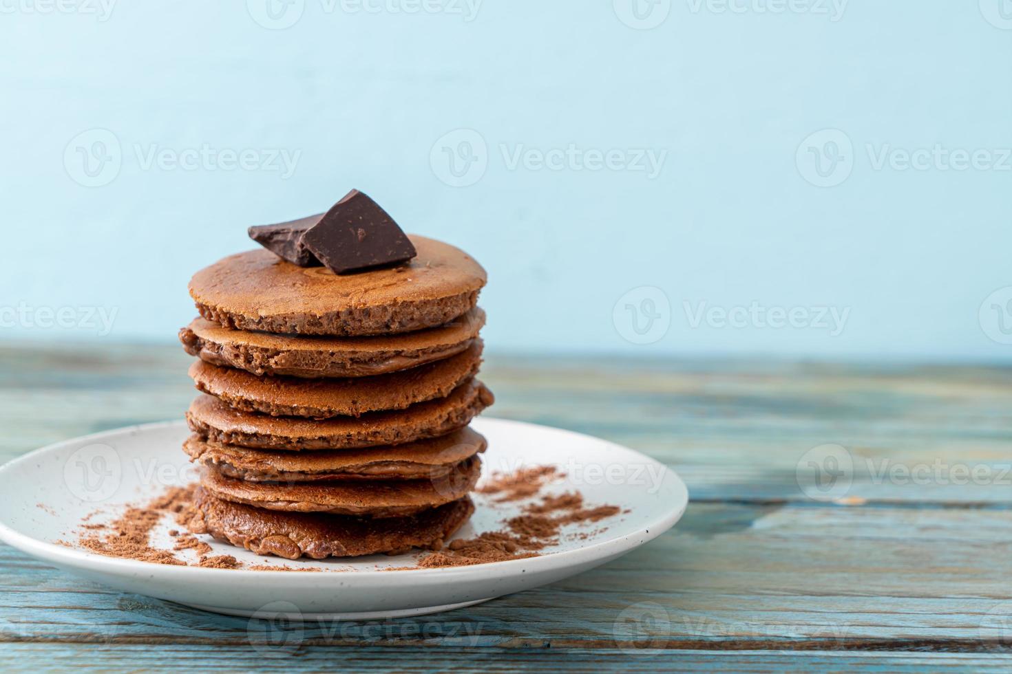 pilha de panqueca de chocolate com chocolate em pó foto