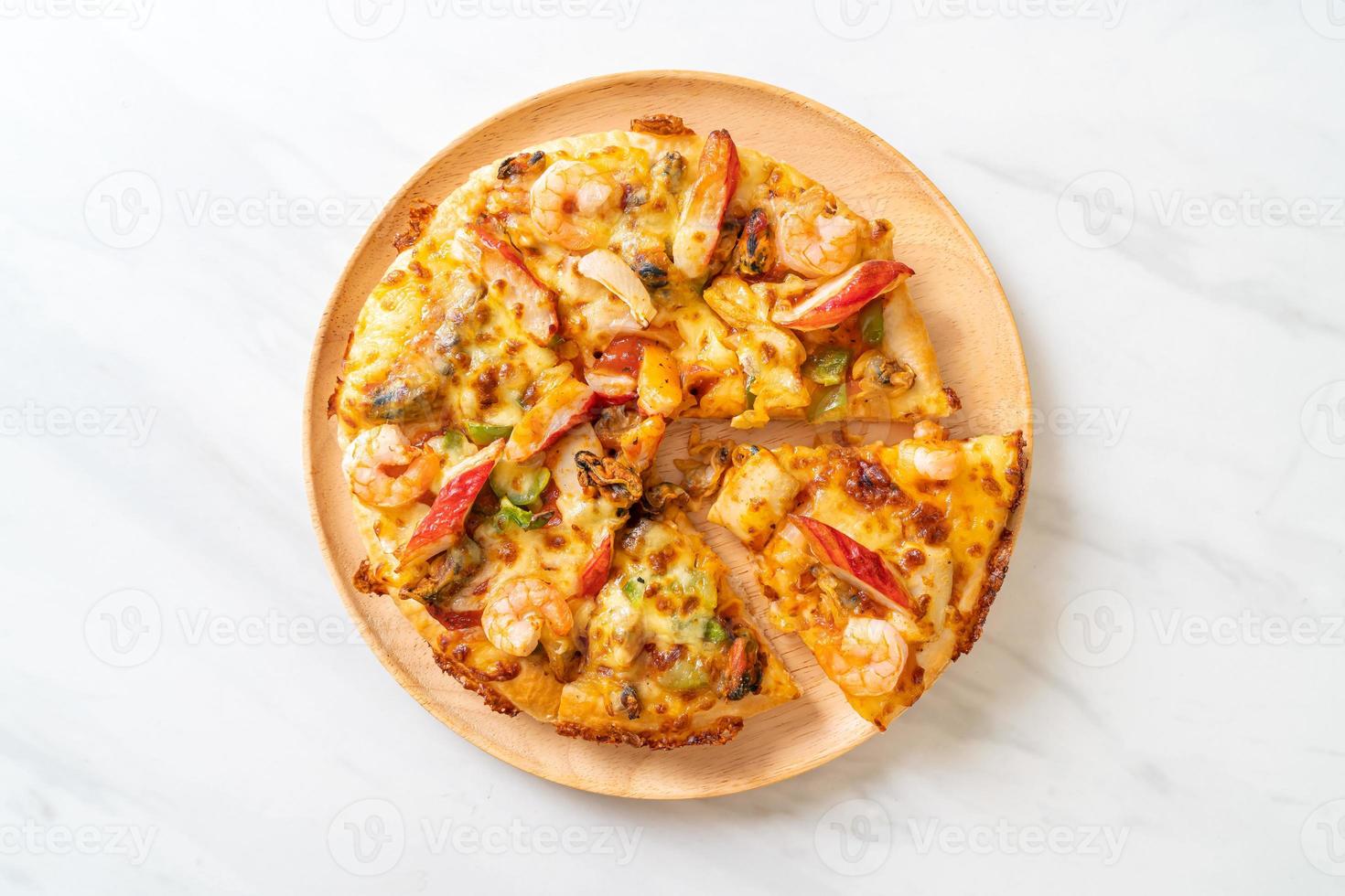 frutos do mar de camarão, polvo, mexilhão e pizza de caranguejo em bandeja de madeira foto