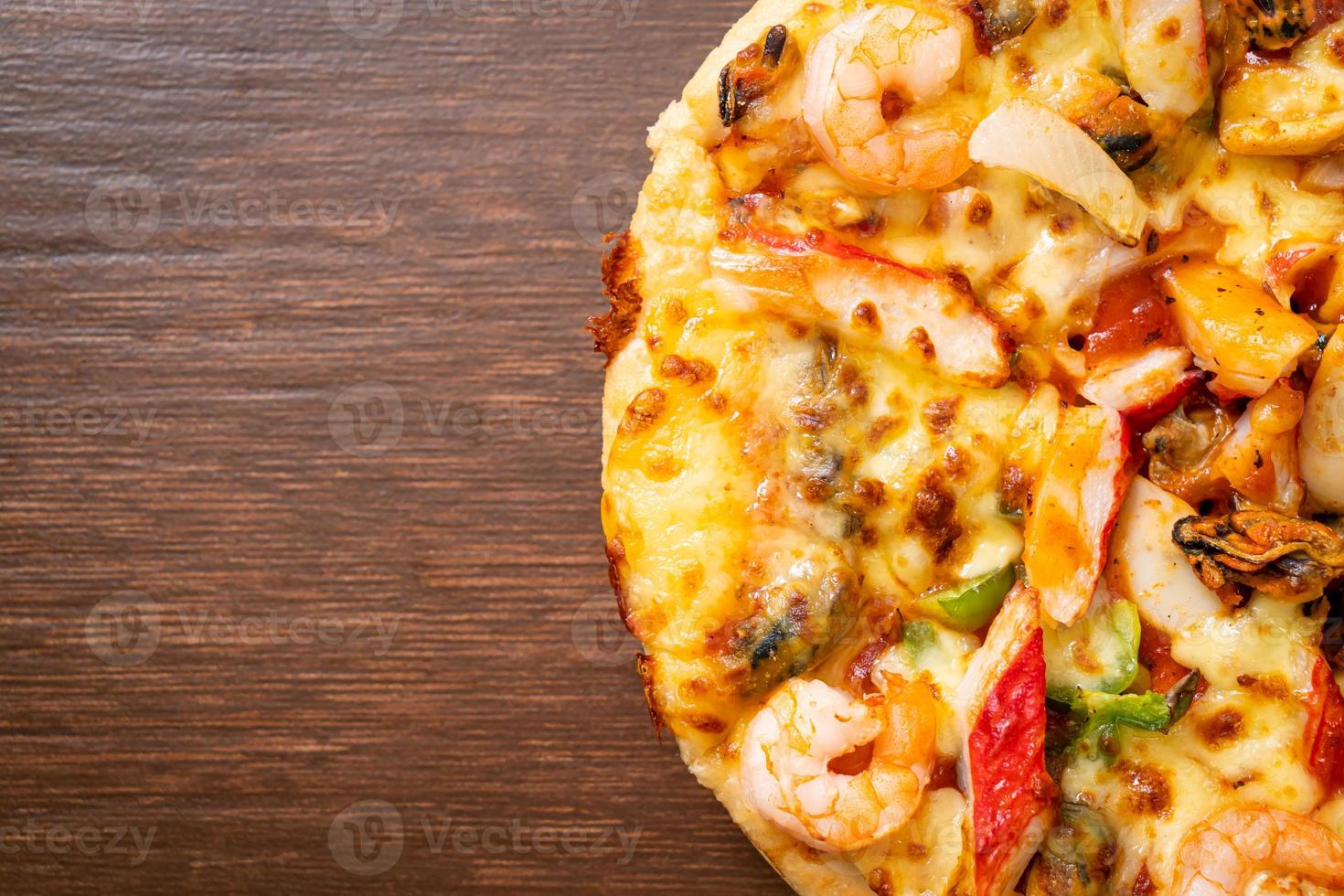 frutos do mar de camarão, polvo, mexilhão e pizza de caranguejo em bandeja de madeira foto