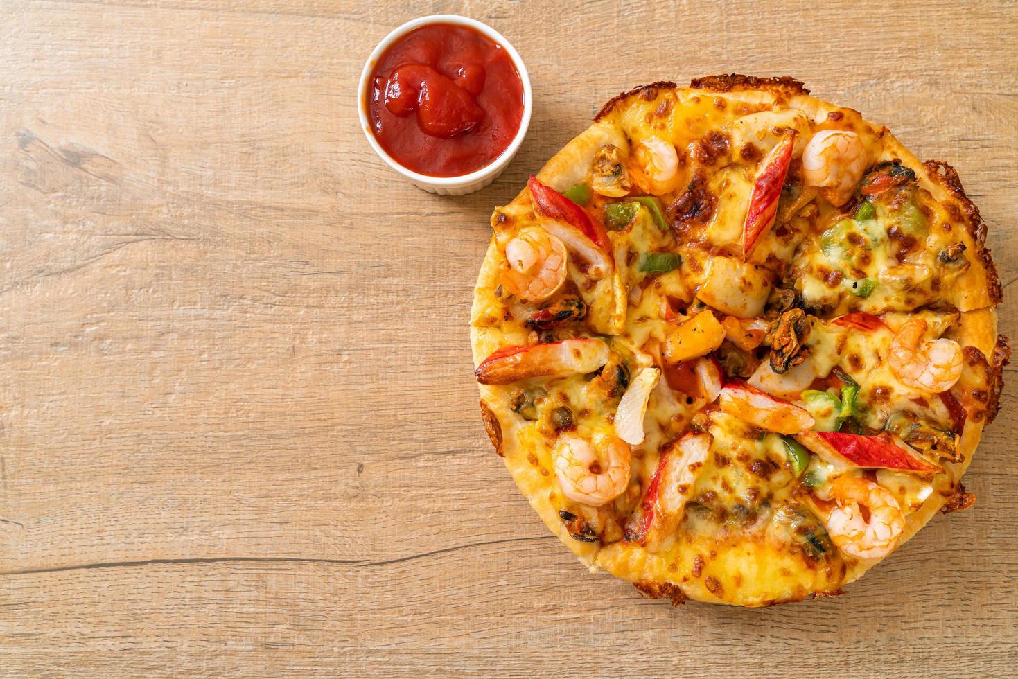 frutos do mar de camarão, polvo, mexilhão e pizza de caranguejo em bandeja de madeira foto