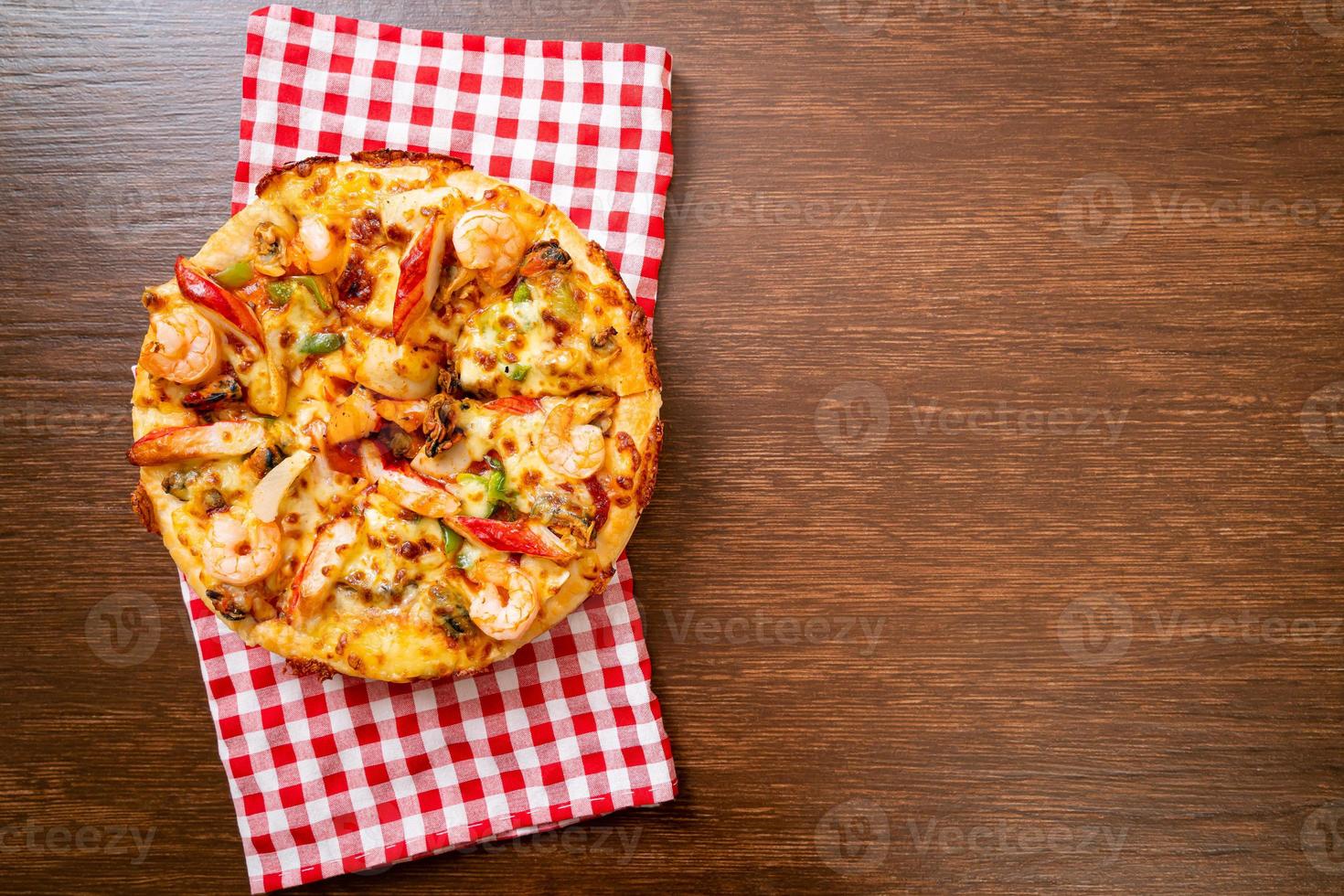 frutos do mar de camarão, polvo, mexilhão e pizza de caranguejo em bandeja de madeira foto