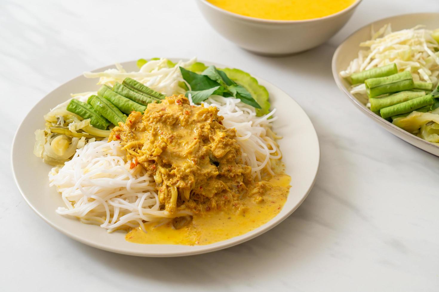 Macarrão de arroz tailandês com caril de caranguejo e vegetais variados foto