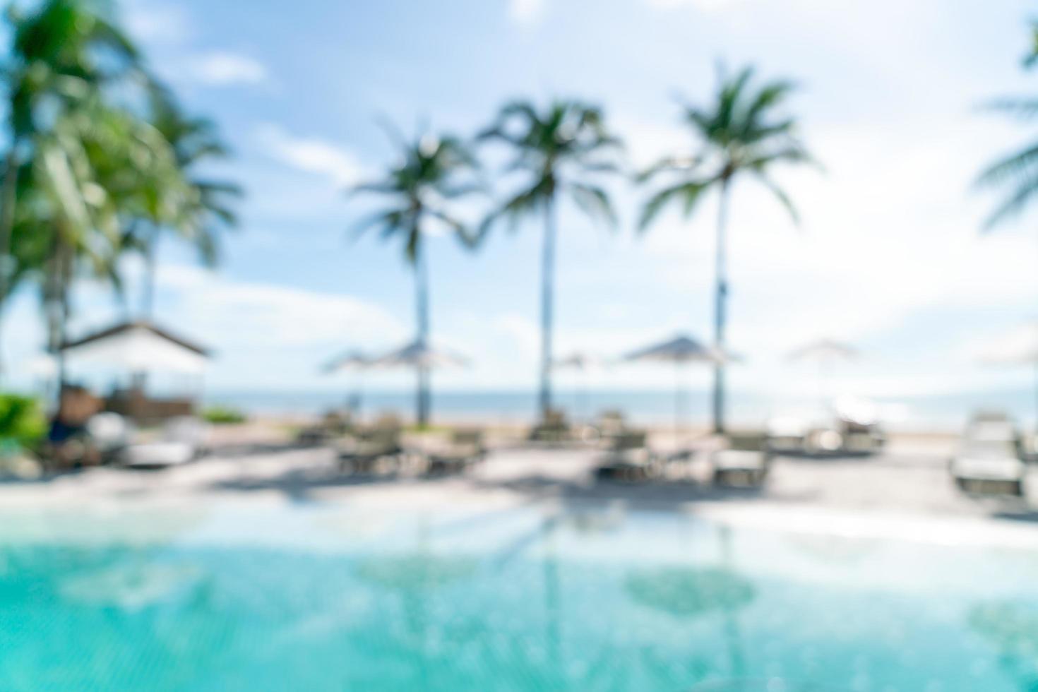 Resumo desfocar a piscina ao redor da piscina em um resort de hotel de luxo como plano de fundo - conceito de férias e férias foto