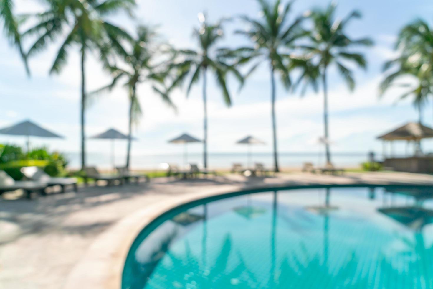 Resumo desfocar a piscina ao redor da piscina em um resort de hotel de luxo como plano de fundo - conceito de férias e férias foto