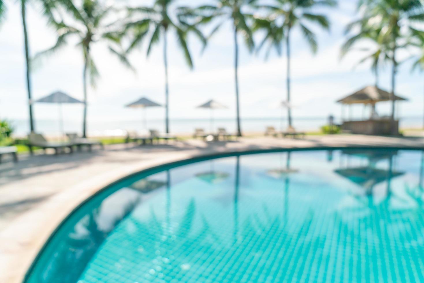 Resumo desfocar a piscina ao redor da piscina em um resort de hotel de luxo como plano de fundo - conceito de férias e férias foto