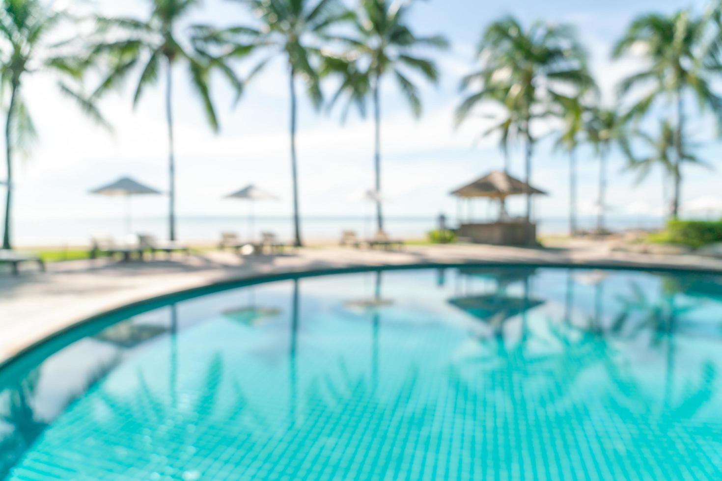 Resumo desfocar a piscina ao redor da piscina em um resort de hotel de luxo como plano de fundo - conceito de férias e férias foto
