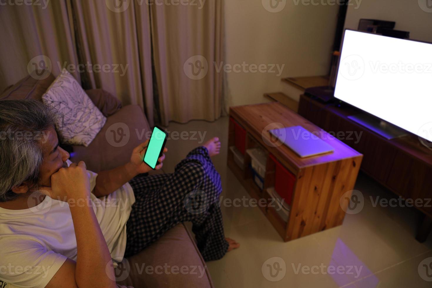 homem asiático assistindo televisão foto