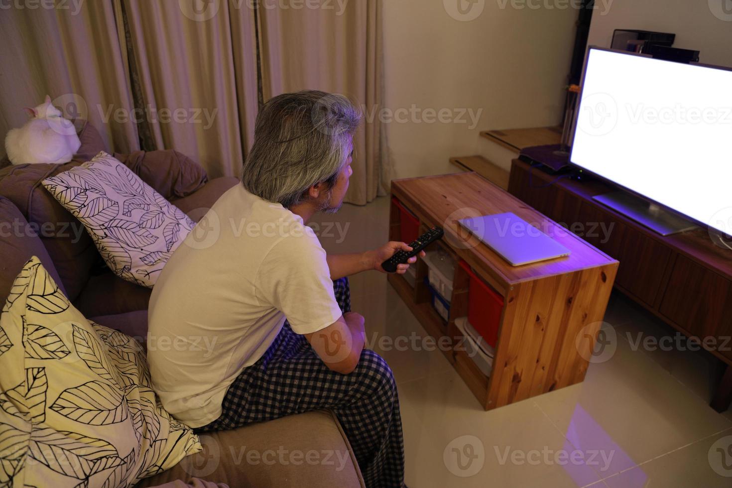 homem asiático assistindo televisão foto