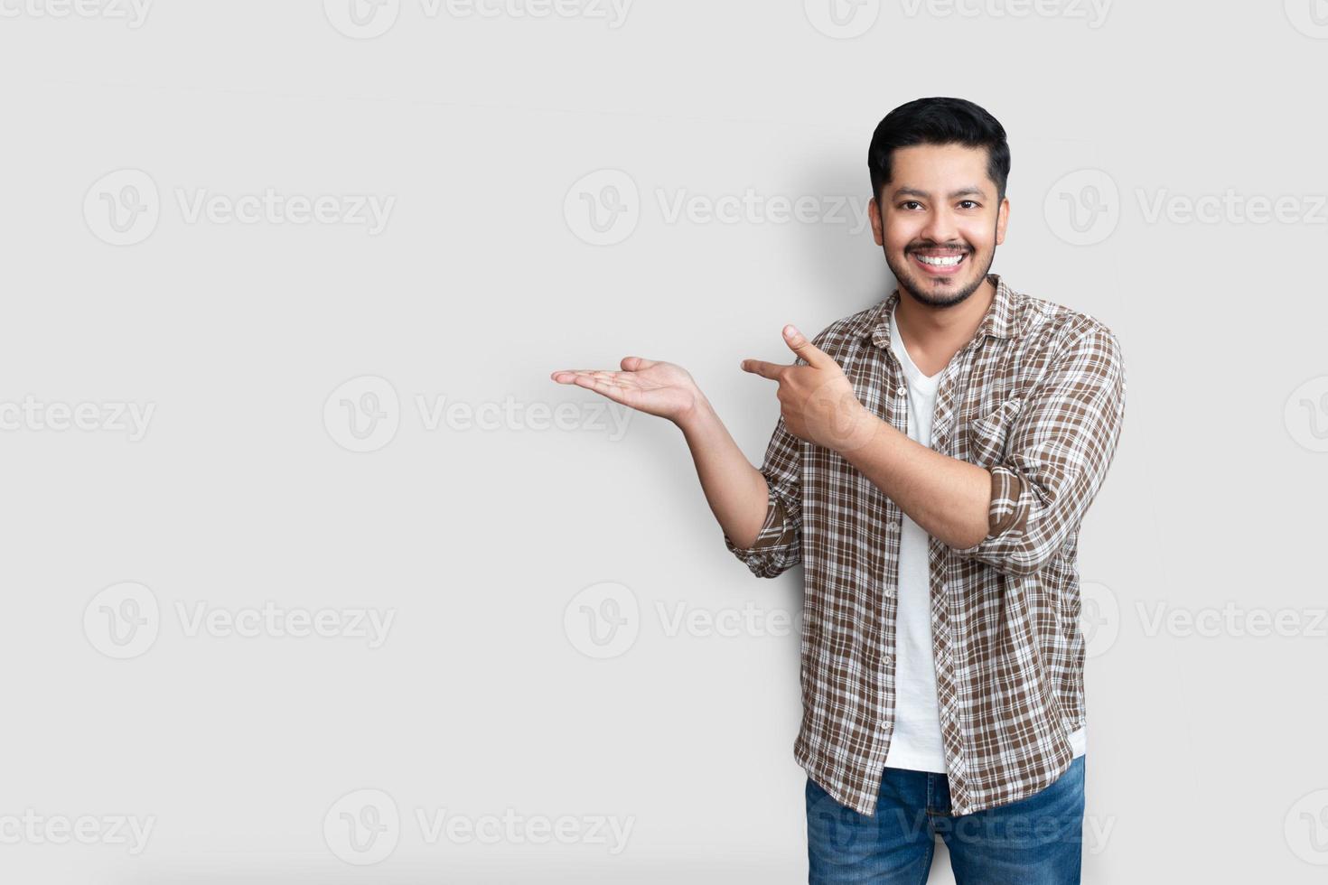 adulto homem asiático sobre fundo isolado sorrindo alegre apresentando e apontando com a palma da mão, olhando para a câmera. foto