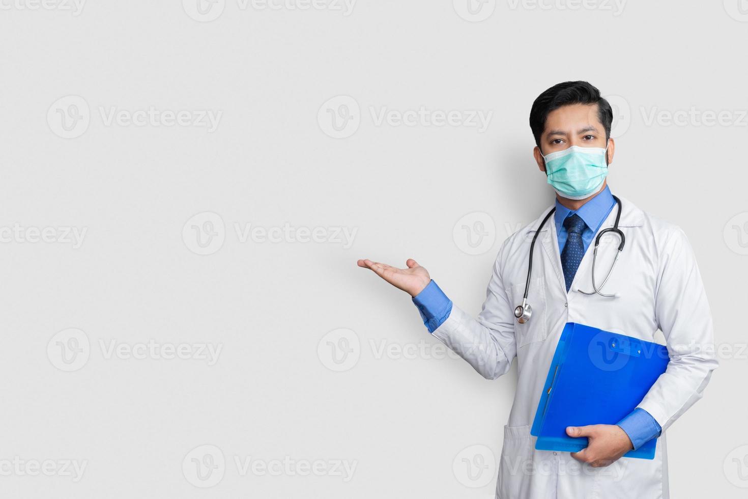 médico segurando o estetoscópio sorrindo enquanto apresenta o arquivo na mão, isolado no fundo branco com espaço de cópia foto
