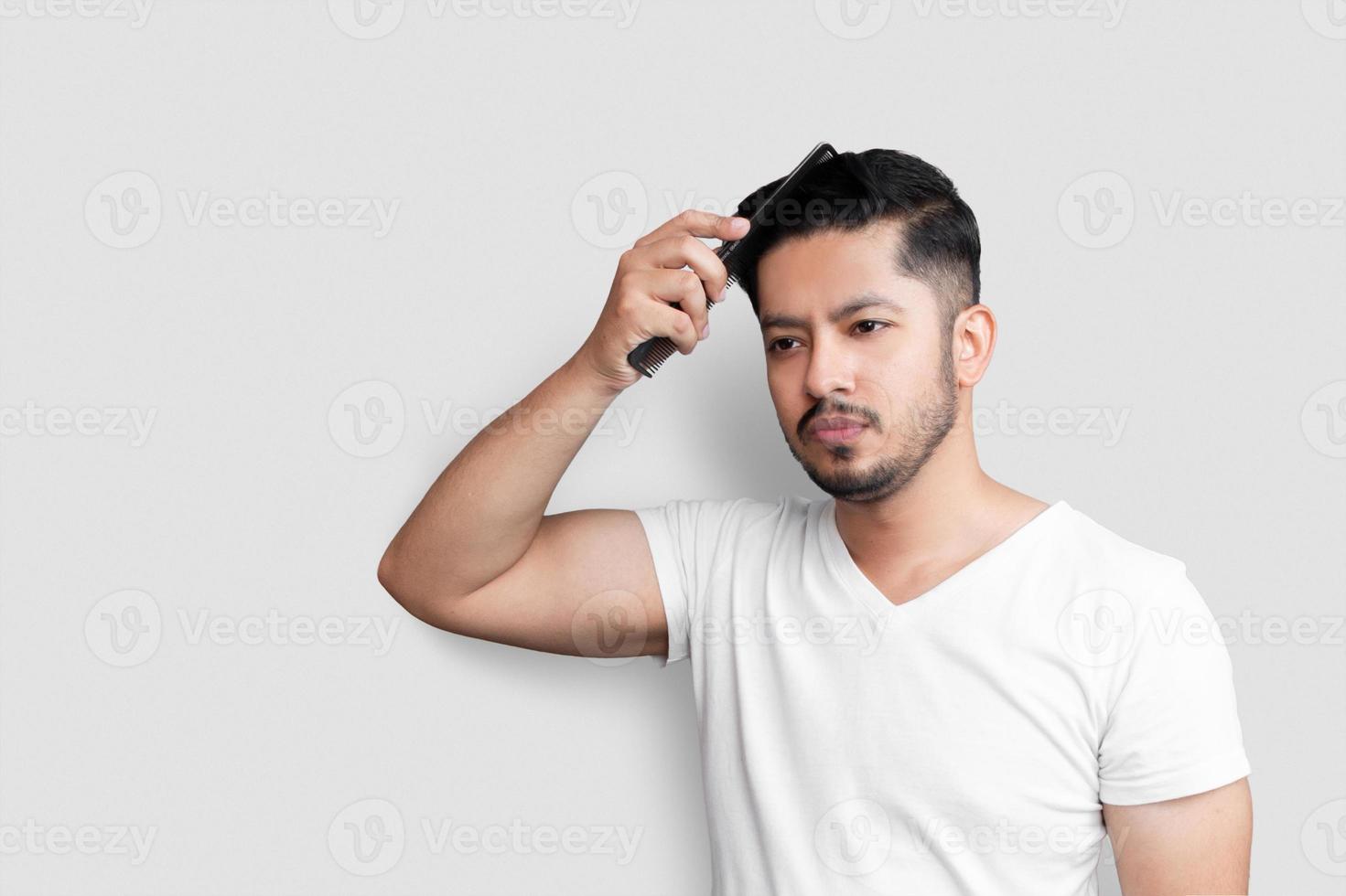 fechar foto incrível juventude aparência perfeita mãos braços escova de penteado de plástico cuidar penteado após barbearia visitar usar camiseta branca casual fundo branco isolado