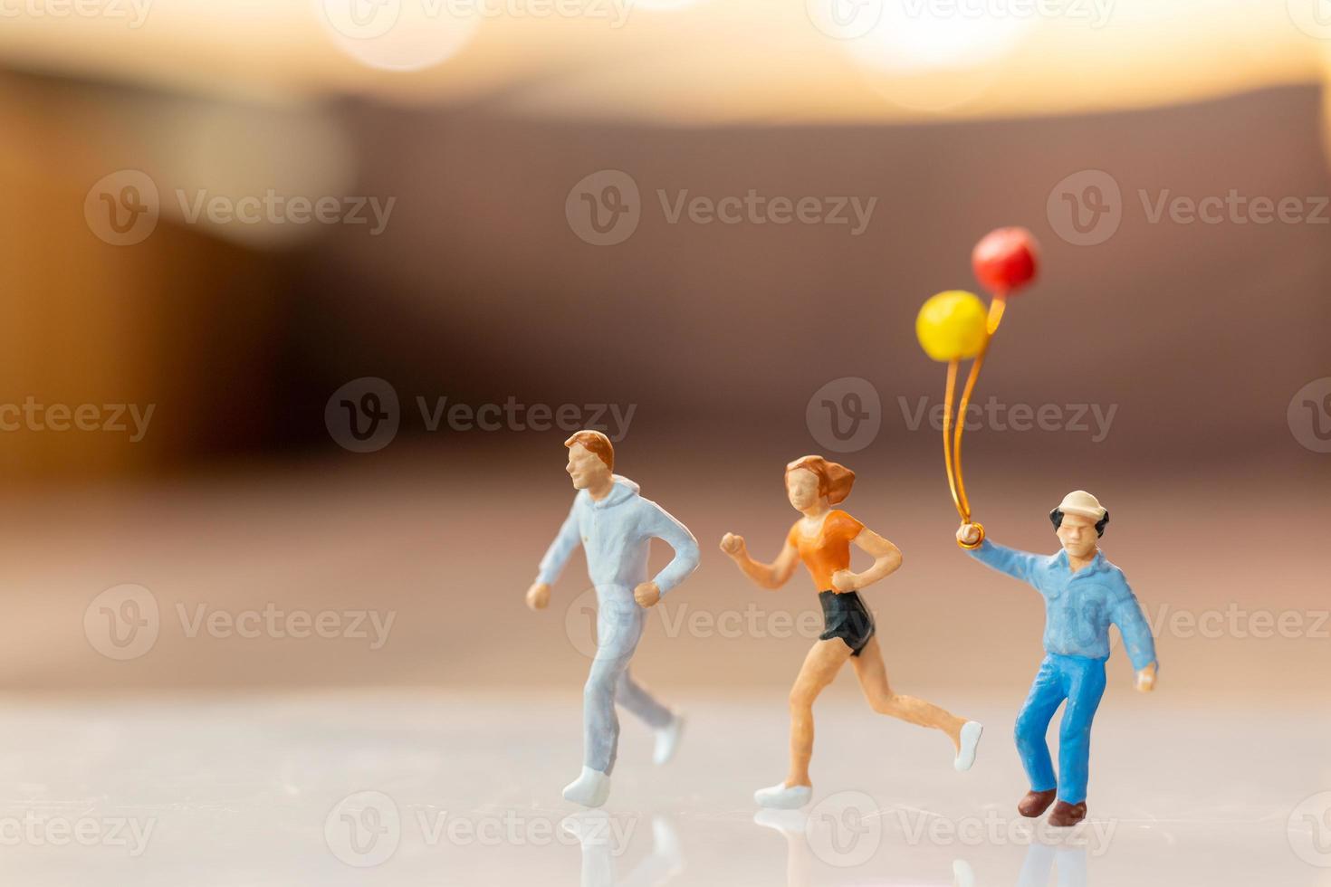 pessoas em miniatura, família feliz correndo e brincando de balão foto