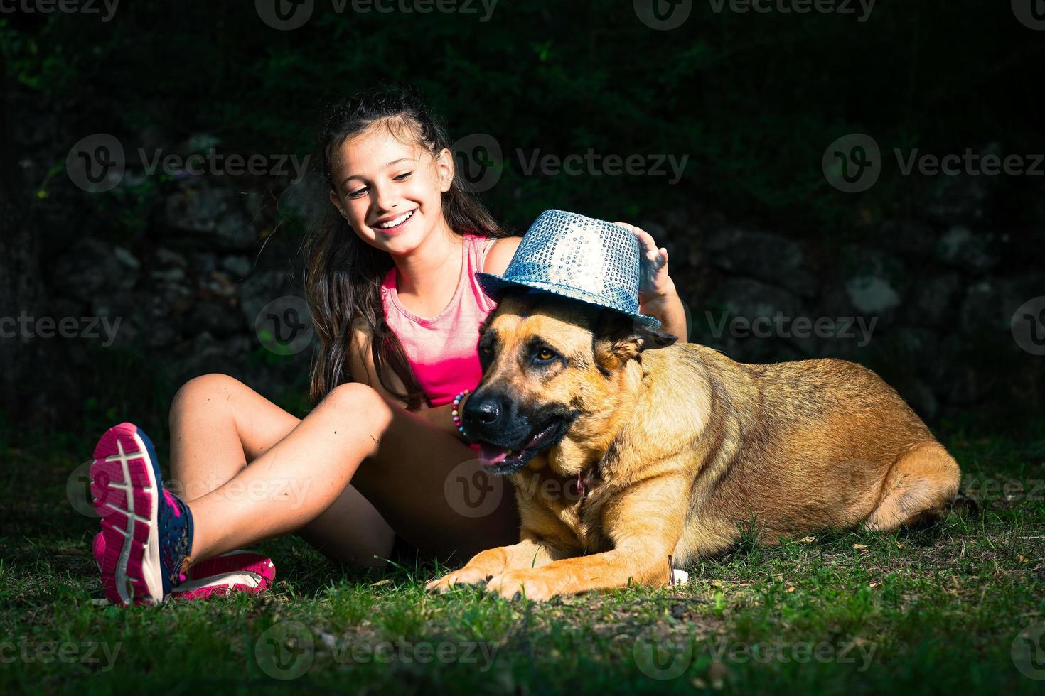 uma menina brinca com seu cão pastor alemão foto