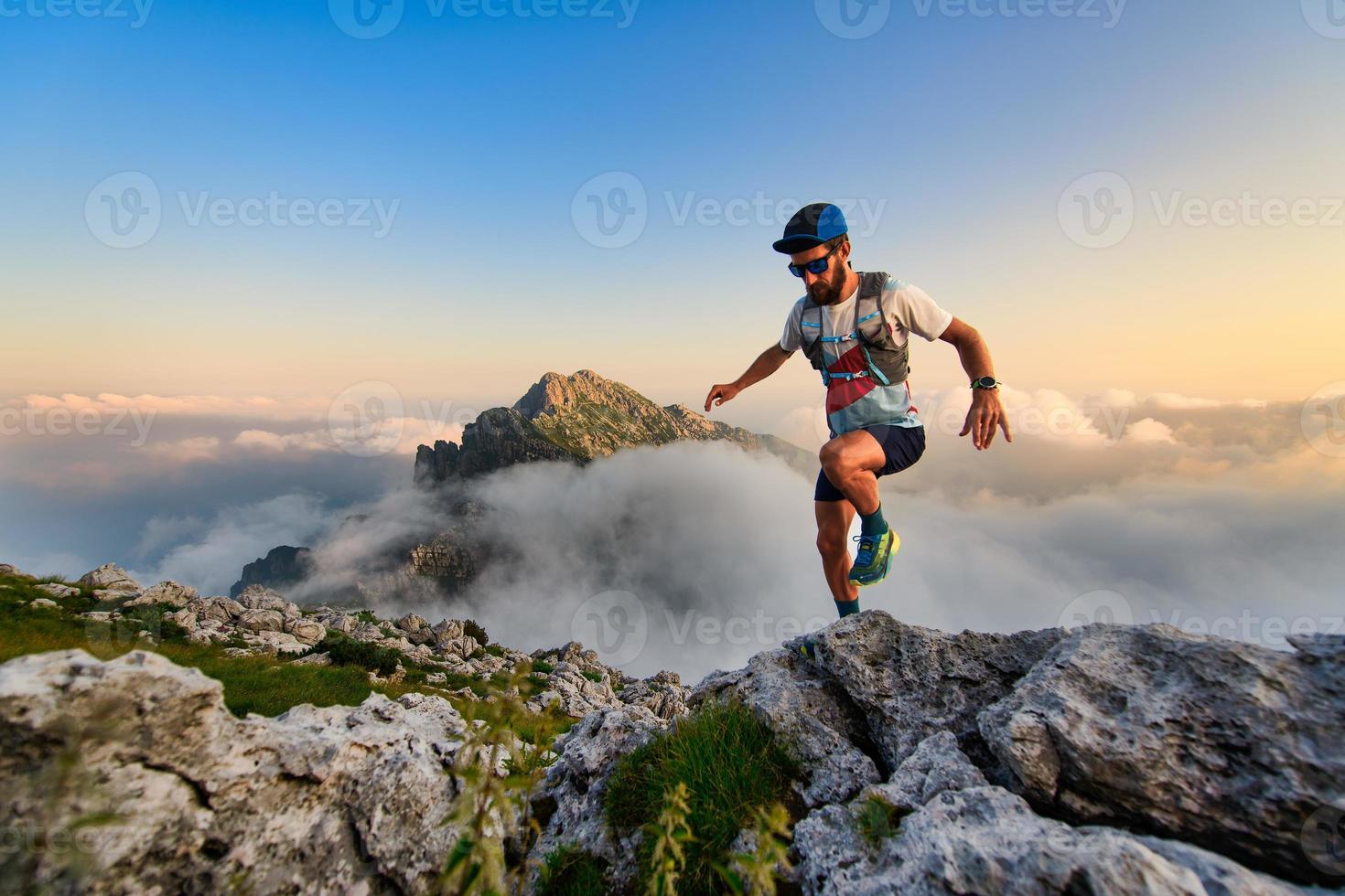 homem corredor de ultramaratona nas montanhas ele treina ao pôr do sol foto