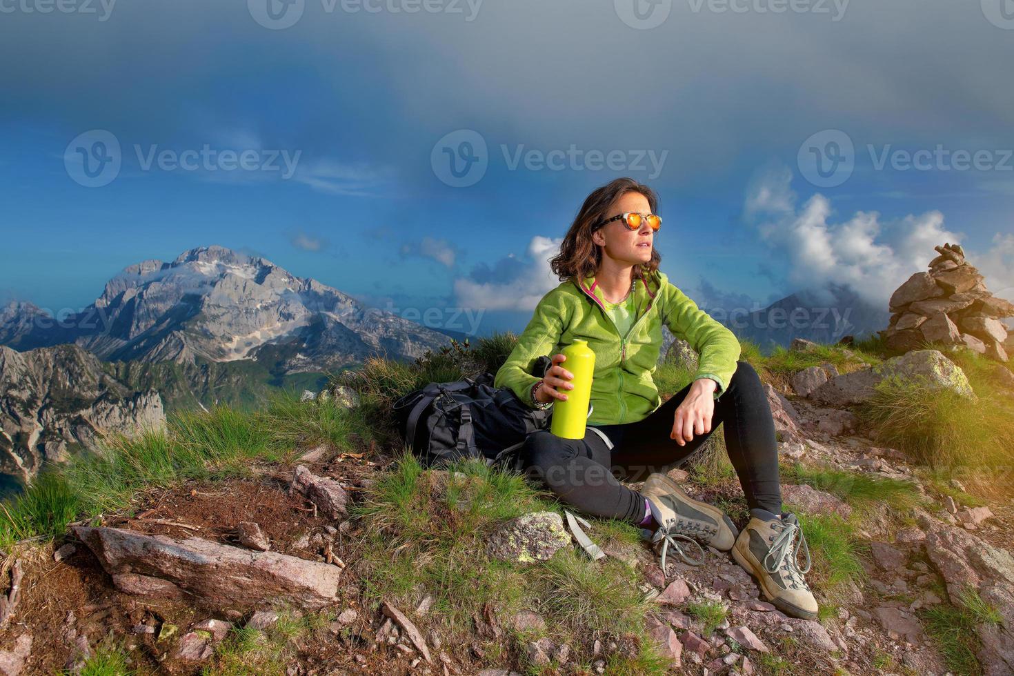 uma garota descansa depois de escalar o topo de uma montanha foto