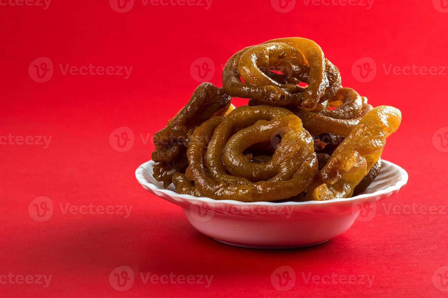 Jalebi doce indiano, Jalebi de sobremesa indiana ou imarti ou imarati ou Jilbi em fundo vermelho foto