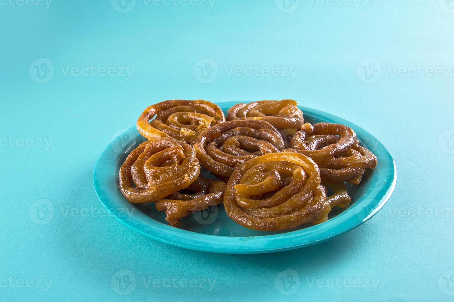 Jalebi doce indiano, Jalebi sobremesa indiana ou imarti ou imarati ou Jilbi em fundo azul foto