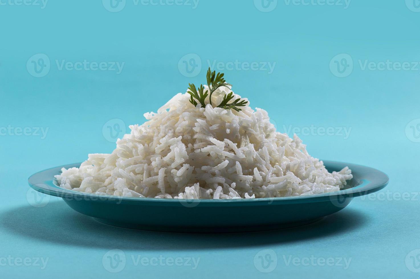 arroz basmati branco puro cozido com corriandro em um prato azul sobre fundo azul foto