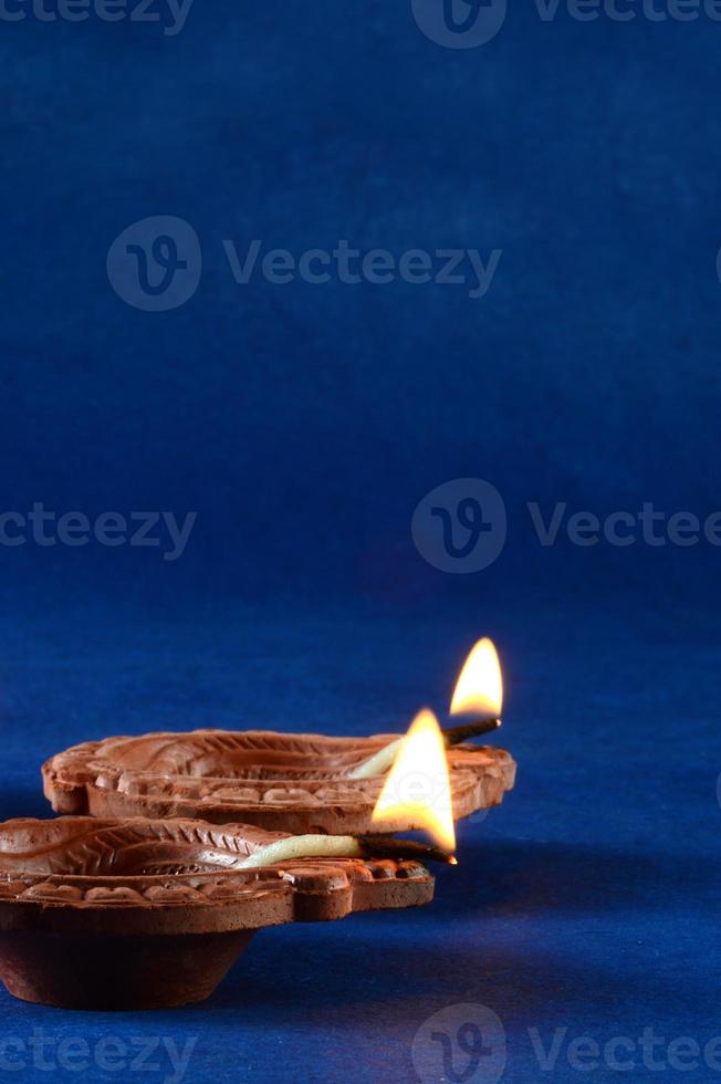 lâmpadas diya de argila acesas durante a celebração do diwali. projeto de cartão de saudações festival indiano da luz hindu chamado diwali foto