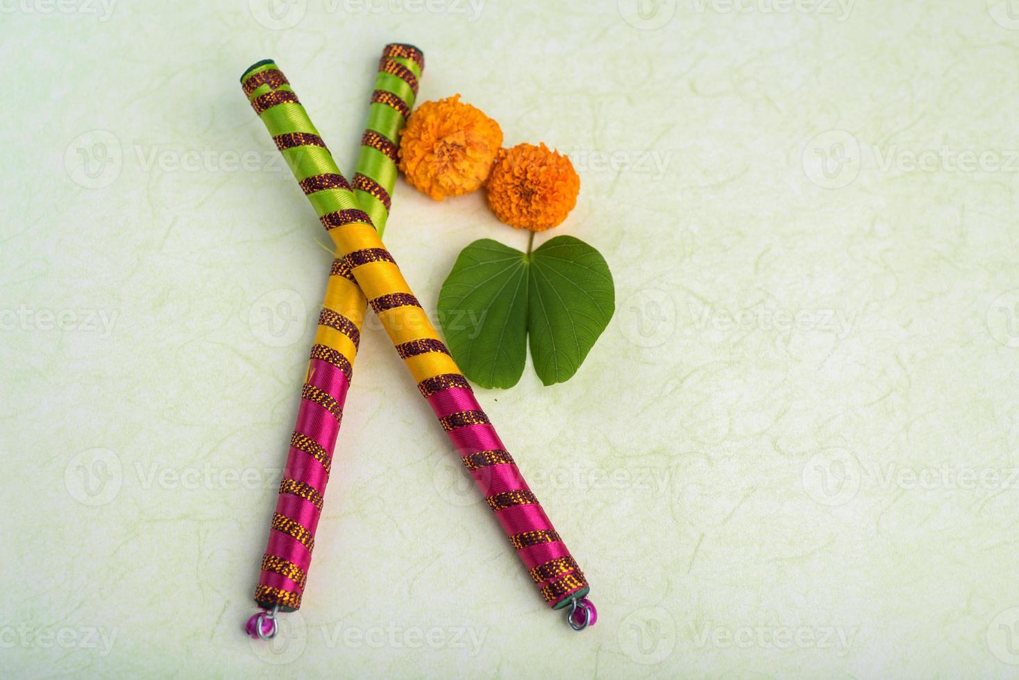 festival indiano dussehra, mostrando folhas douradas de bauhinia racemosa e flores de calêndula com paus de dandiya. foto