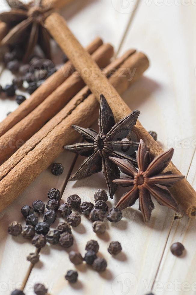 especiarias e ervas. alimentos e ingredientes da cozinha. paus de canela, estrelas de anis e pimenta preta em um fundo de madeira. foto