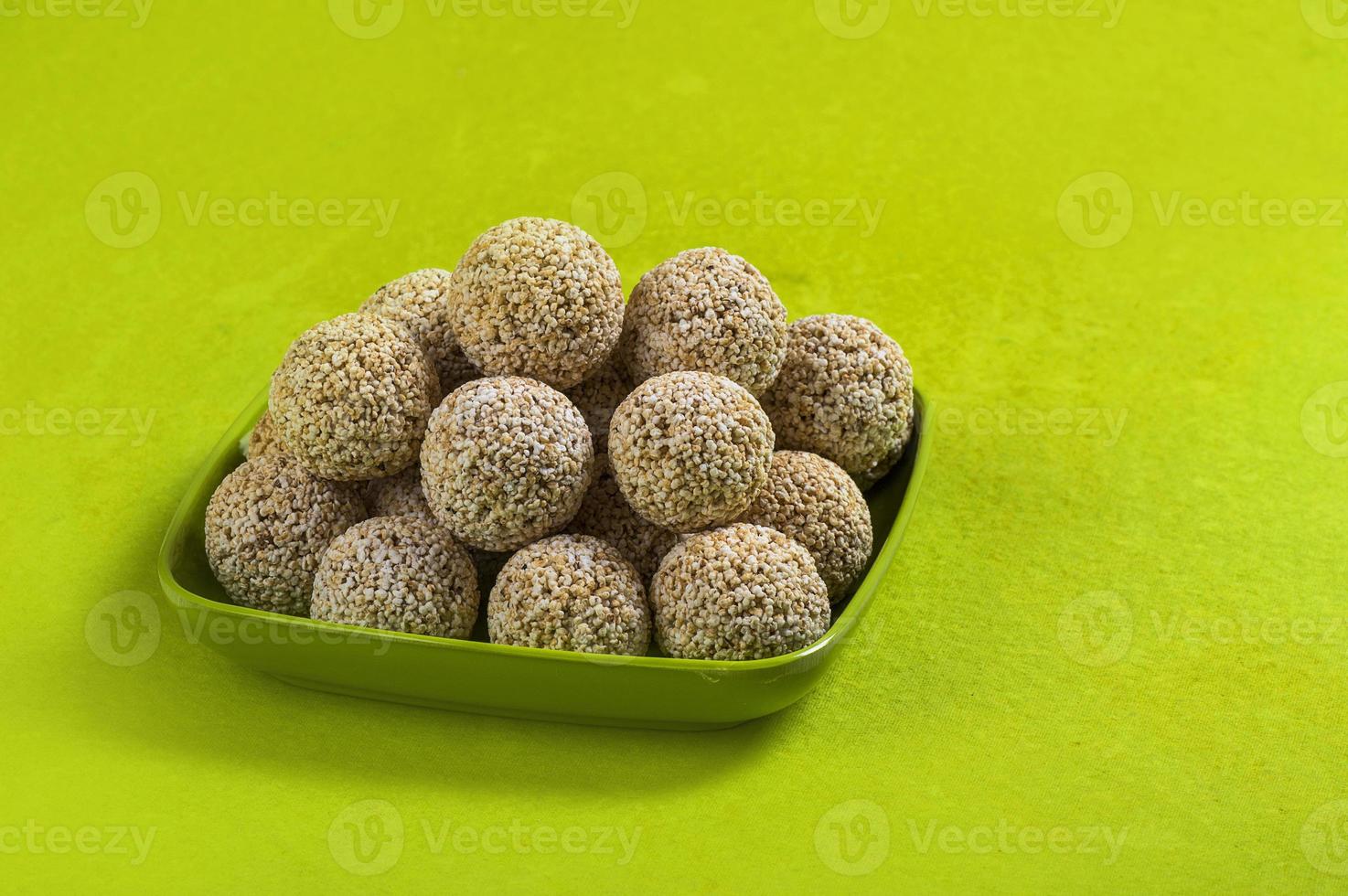 amaranto ou rajgira laddu, cholai ke laddo em placa verde sobre fundo verde foto